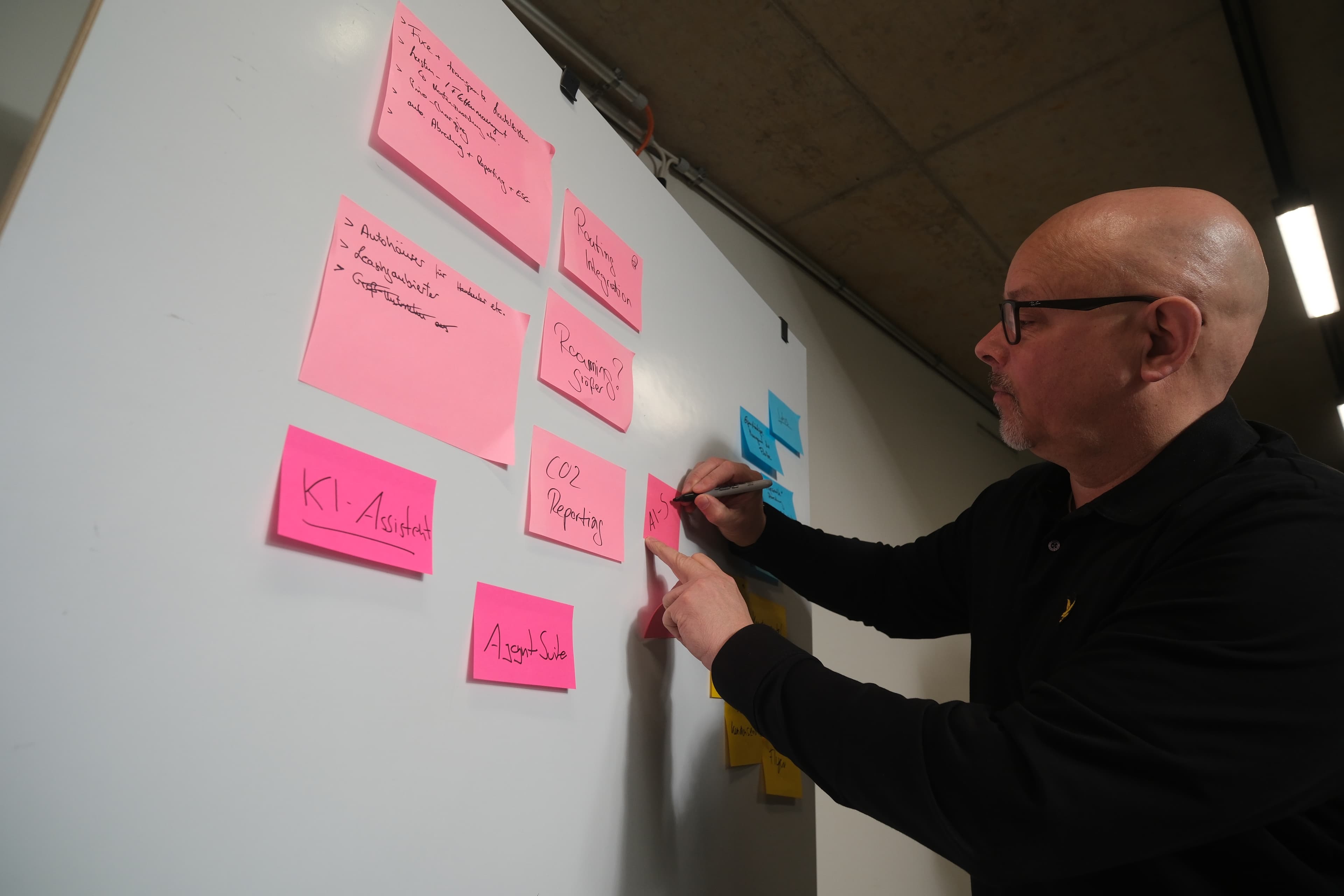 Berater am Whiteboard mit KI-Strategie Post-its